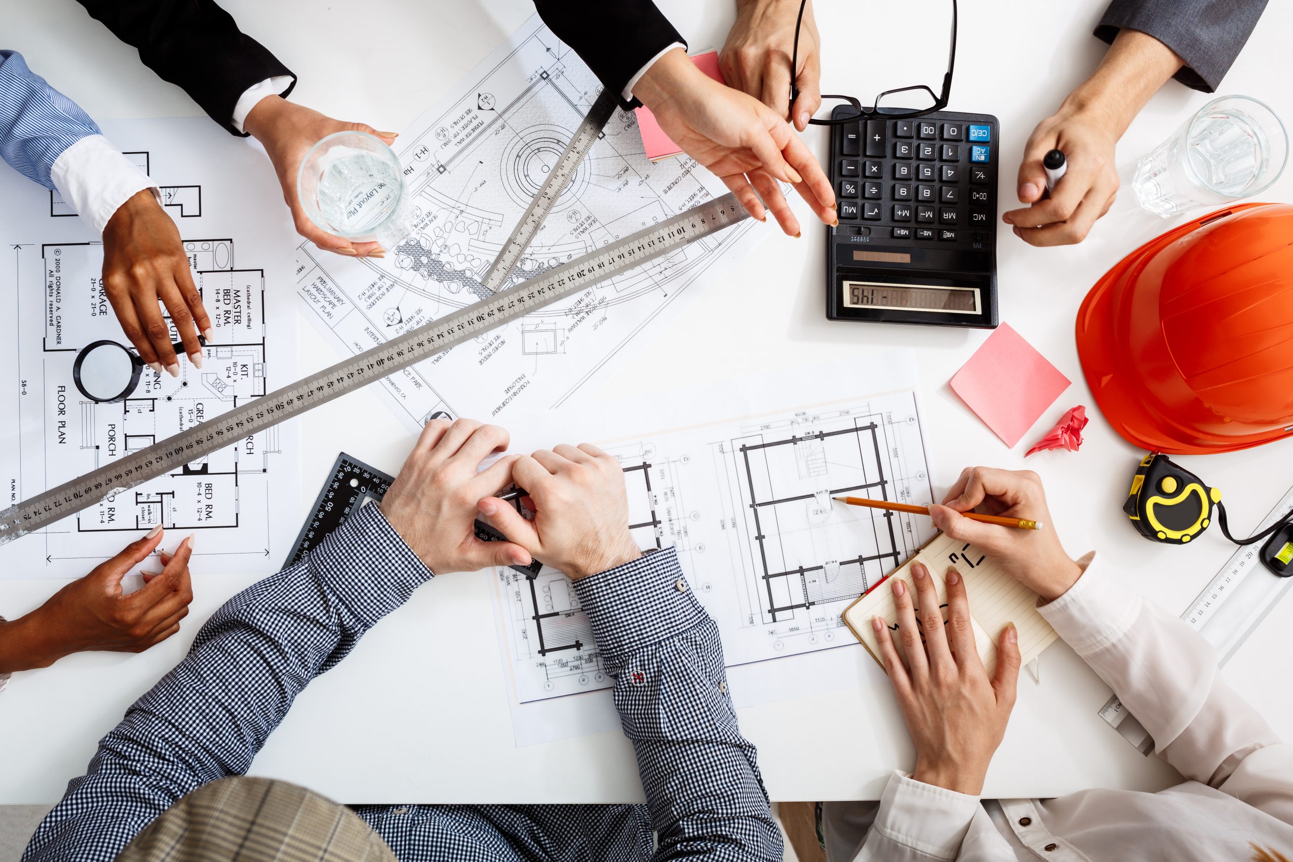 Picture of businessmen’s hands on white table with documents and drafts